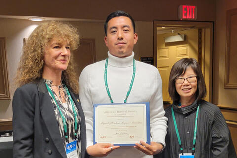 Miguel posing with award