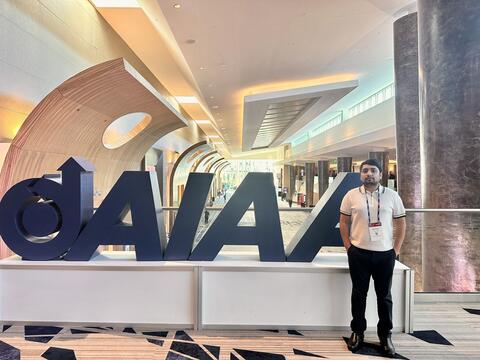 Rabin in front of the AIAA Logo