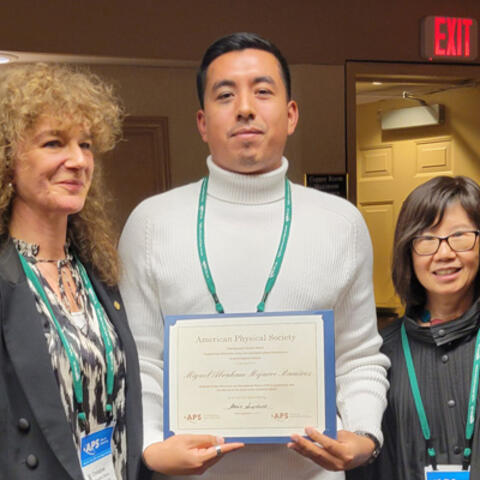 Miguel posing with award