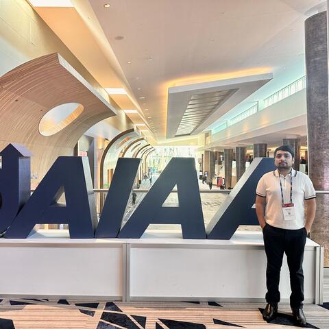 Rabin in front of the AIAA Logo